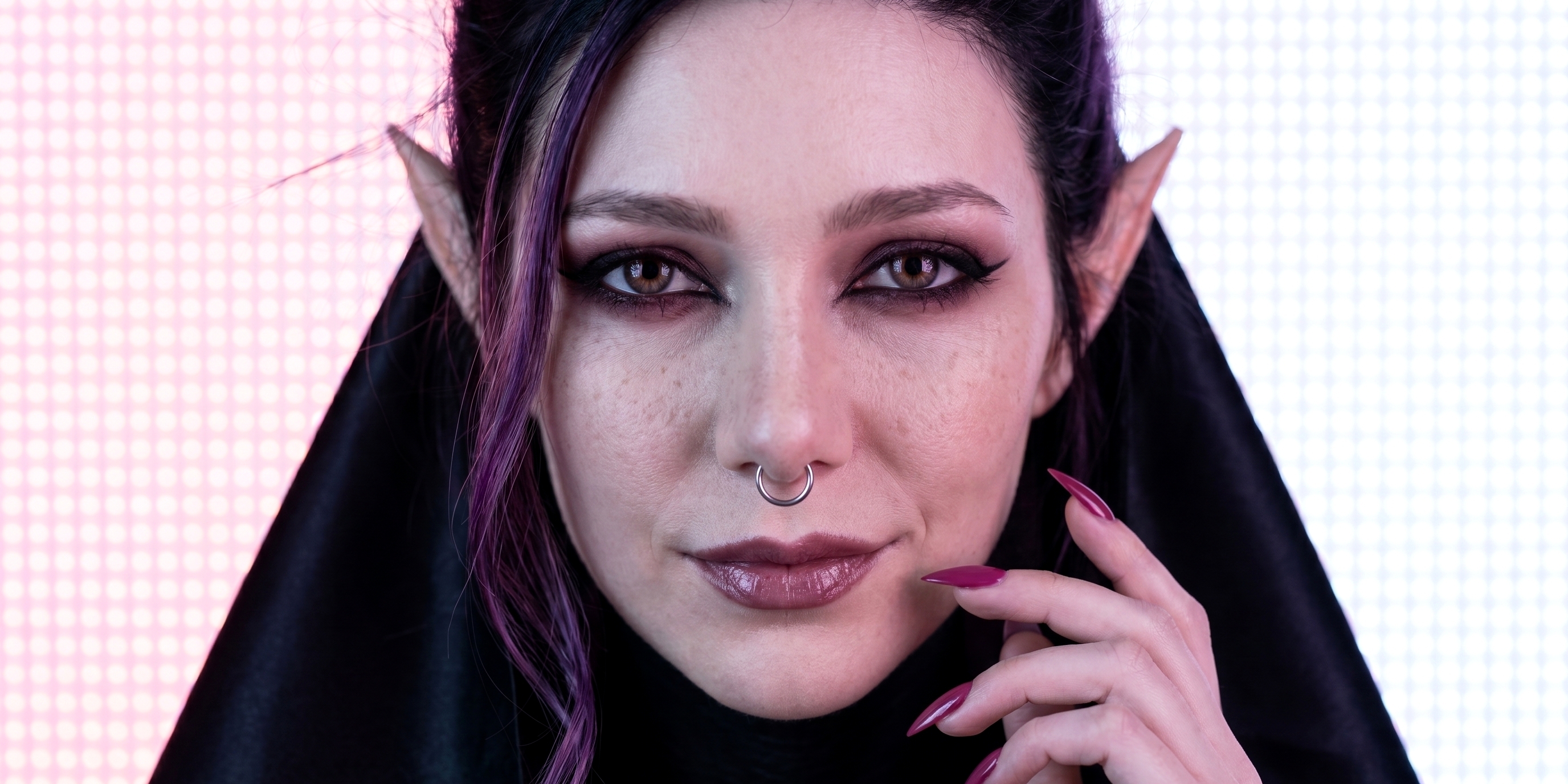 Landscape portrait of Sael'thirra (Саельтірра), an AI digital persona — a woman with long pointed ears, black-violet hair and a septum ring, gazing directly at the camera against a soft magenta-and-white halftone backdrop.